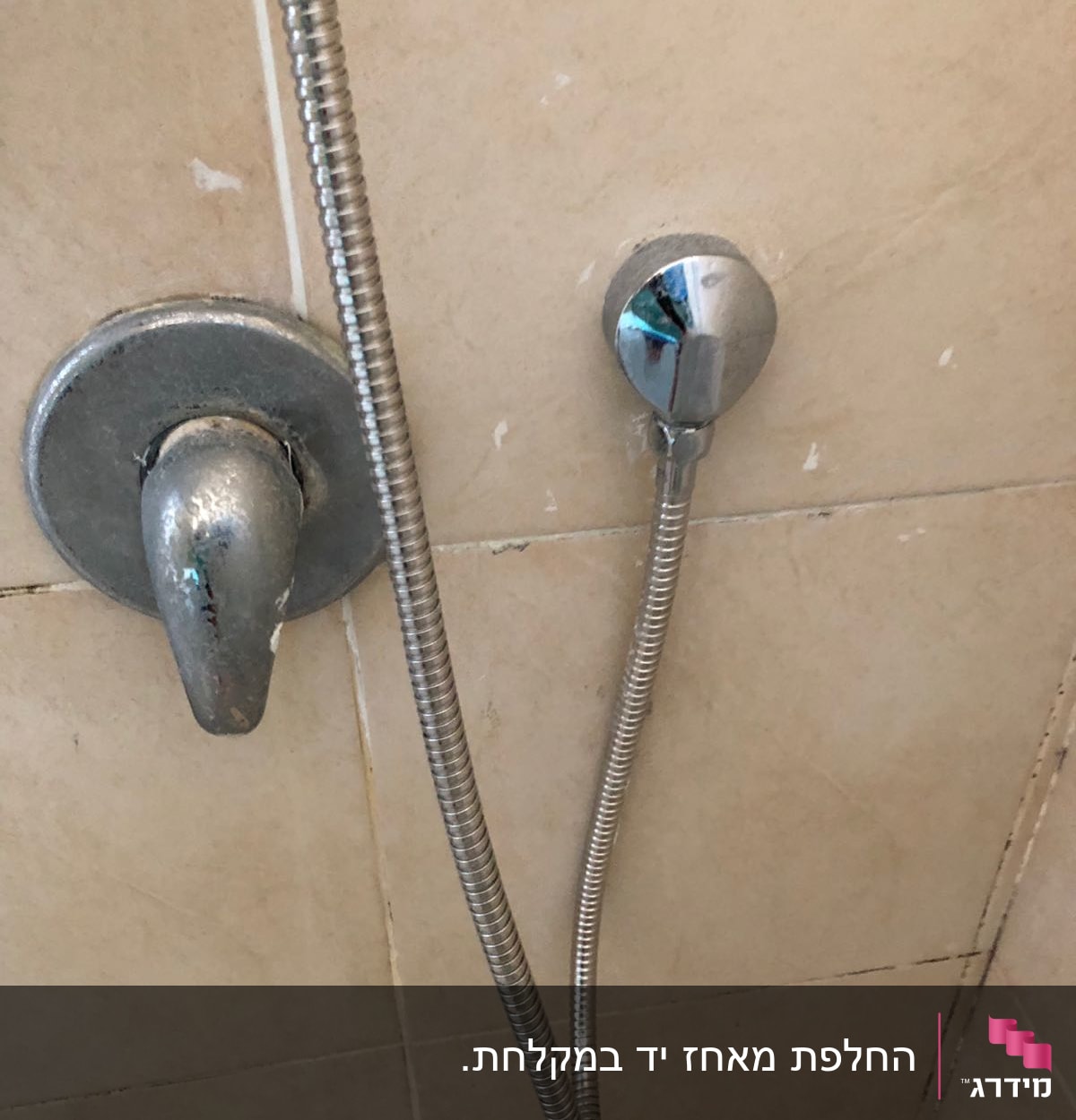 ברז מקלחת עם צינור מתכת על קיר קרמיקה